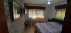 - une chambre avec un lit et un mur en pierre dans l'établissement Apart Hotel Red Dto 1, à Pontevedra