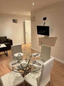 a living room with a glass table and white chairs at 021- Two bedrooms in Ealing 2 in Ealing