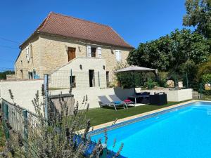 a house with a swimming pool in front of a house at Picturesque renovated farmhouse with pool in Les Junies