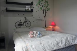 um quarto com uma cama e uma bicicleta na parede em Cozy Rabbit Hotel em Thung Song