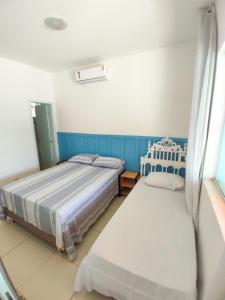 瓜拉久巴的住宿－Vivenda das Águas Guarajuba，一间卧室设有两张床和窗户。