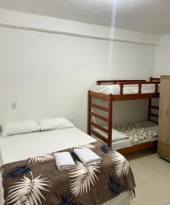 מיטה או מיטות קומותיים בחדר ב-Sol e mar suítes maragogi