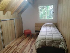 Habitación pequeña con cama y ventana en Cielo de sierra en Sierra de los Padres