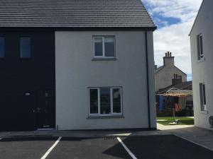 a white house with a window in a parking lot at Central Spacious 2 Bed 2 Bath, Free WiFi & Parking, Park View in Orkney