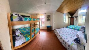 a bedroom with two bunk beds in a room at Arte sin Fronteras Hostel in Paipa