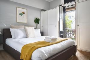 a bedroom with a bed with a yellow blanket on it at Redfern Classic Terrace - Parking and Balcony in Sydney