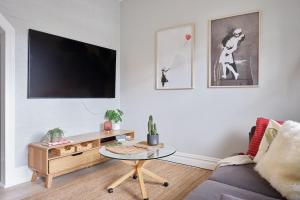 a living room with a tv and a coffee table at Redfern Classic Terrace - Parking and Balcony in Sydney