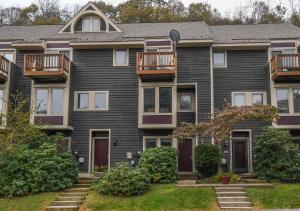 a large house with black siding and balconies at Villages of Wisp 08 Winding Way in McHenry