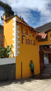 a person standing in front of a yellow building at La Finca Tarma in Tarma