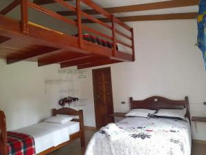 1 dormitorio con 2 camas y 1 cama elevada en Los Tordos del Parral, en Samaipata