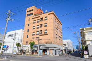 wysoki ceglany budynek na rogu ulicy w obiekcie Hotel Emerald Isle Ishigakijima w mieście Ishigaki