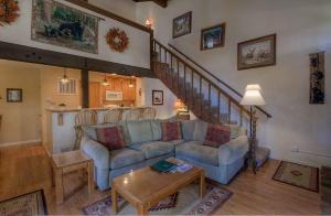 a living room with a couch and a staircase at Bear Lake Hideaway condo in South Lake Tahoe
