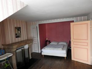 een slaapkamer met een bed en een open haard bij Gîte Perrancey-les-Vieux-Moulins, 3 pièces, 4 personnes - FR-1-611-22 in Perrancey