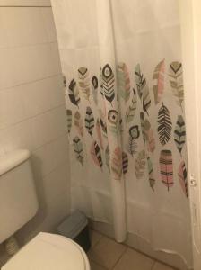 baño con aseo y cortina de ducha con plumas en Prunus en Mendoza