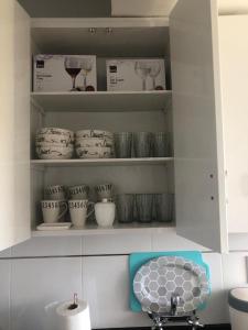 un armario de cocina lleno de platos y copas de vino en Prunus en Mendoza