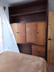 a bedroom with wooden cabinets and a bed at Departamento Lirio in San Miguel de Allende