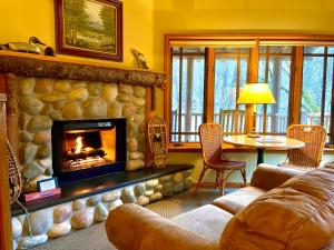 sala de estar con chimenea, mesa y sofá en Weasku Inn, en Grants Pass