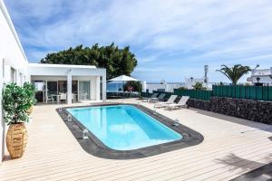 a swimming pool on a deck next to a house at Luxury Casa El Marques in Puerto del Carmen