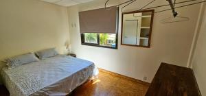 查克拉斯德科里亞的住宿－DEPTO EN CHACRAS DE CORiA，一间卧室配有一张床、镜子和一张桌子