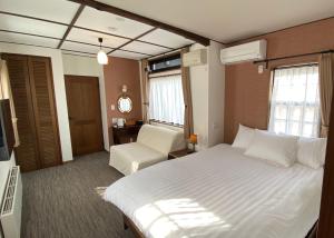 Habitación de hotel con cama y silla en Shinkyo Inn, en Nikko