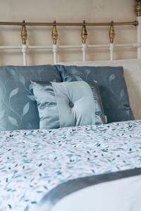 1 cama con almohadas azules y cabecero blanco en A PEACEFUL DOUBLE BEDROOM IN LEEDS, en Hunslet