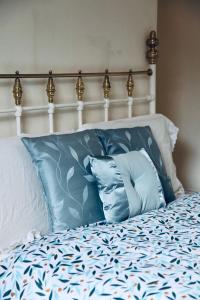 Una cama con almohadas azules encima. en A PEACEFUL DOUBLE BEDROOM IN LEEDS, en Hunslet