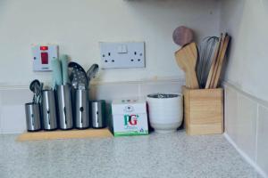 a kitchen counter with a shelf with cooking utensils at A PEACEFUL DOUBLE BEDROOM IN LEEDS in Hunslet