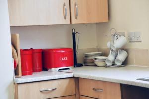 encimera de cocina con tostadora roja y vajilla en A PEACEFUL DOUBLE BEDROOM IN LEEDS, en Hunslet