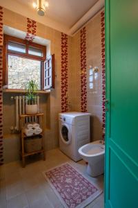 Artemisia Homes - Villa Cristina al Mare في مارينا بورتو: حمام مع غسالة ومرحاض