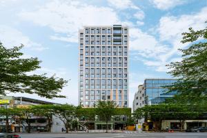 Un edificio alto y blanco con muchas ventanas. en Urbanstay Myeongdong, en Seúl