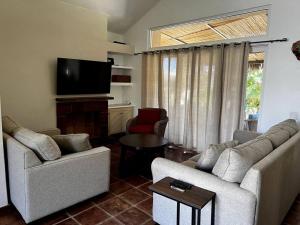 sala de estar con 2 sofás y TV de pantalla plana en FREE CAR W/ Private House & Ocean View, en El Bedito