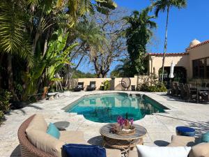 a swimming pool in a backyard with chairs and a table at Casa Belmar Miami in Miami