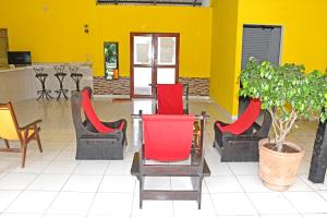 a lobby with red chairs and a yellow wall at Hotel Ambaibo in Rurrenabaque