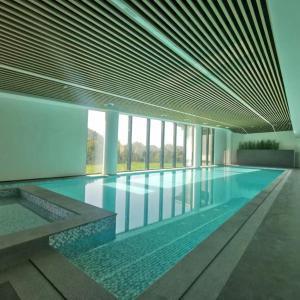 uma grande piscina num edifício com janelas em S&N Hotel Wucheng em Yongxiu
