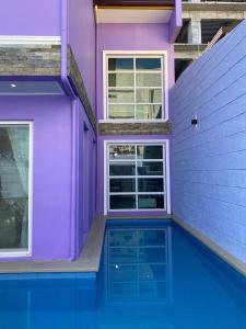 a purple house with a swimming pool in front of it at On Pool Villa in Fort Stotsenburg