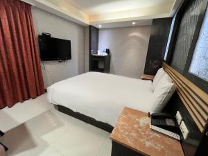 a hotel room with a bed and a television at Guide Hotel Taipei Xinyi in Taipei