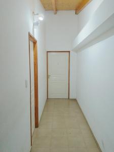 una habitación vacía con una pared blanca y una puerta en Departamentos El Mirador en Ushuaia