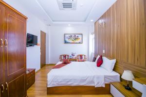 - une chambre avec un lit blanc et des placards en bois dans l'établissement Anh Thảo Hotel Quy Nhơn, à Quy Nhơn