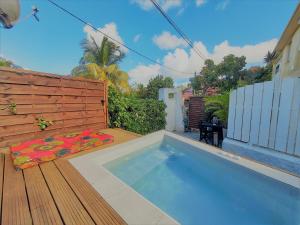 - une piscine dans un jardin avec une terrasse en bois dans l'établissement Ocean BAYALOCATION, à LʼAnse Mitan