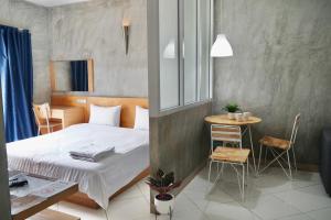 a small room with a bed and a table in it at The View Residence in Bangkok
