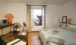 a small bedroom with a bed and a window at Saint-Vincent in Saint-Tropez