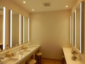 a bathroom with two sinks and two mirrors at Kanazawa Sainoniwa Hotel in Kanazawa