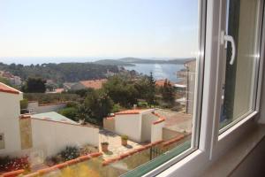 een raam met uitzicht op een stad en de oceaan bij Hvar Adria in Hvar