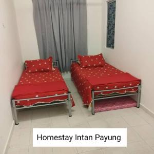 duas camas com almofadas vermelhas num quarto em Homestay Intan Payung Mitc em Ayer Keroh
