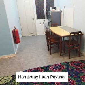 a kitchen with a table and chairs and a refrigerator at Homestay Intan Payung Mitc in Ayer Keroh