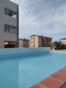 a large swimming pool in front of a building at Apartamento Icaraí prox ao cumbuco in Caucaia