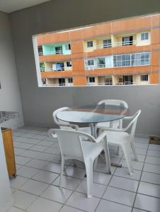 uma mesa e cadeiras numa varanda com uma janela em Apartamento Icaraí prox ao cumbuco em Caucaia