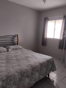 um quarto com uma cama e uma janela em Apartamento Icaraí prox ao cumbuco em Caucaia