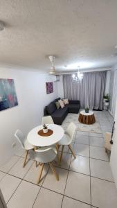 a living room with a table and chairs and a couch at 3 BLOCKS to SURFERS PARADISE BEACH in Gold Coast