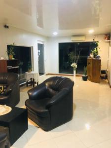 a living room with two leather chairs and a couch at Pinidiya Resort in Anuradhapura